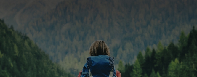 Background of mountains with a backpacker looking at it